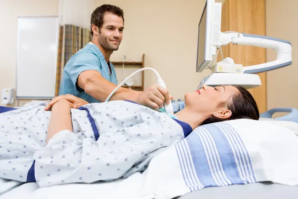 Enfermera realizando ultrasonido en el cuello del paciente —  Fotos de Stock