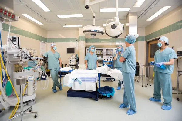 Équipe médicale discutant en salle d'opération — Photo
