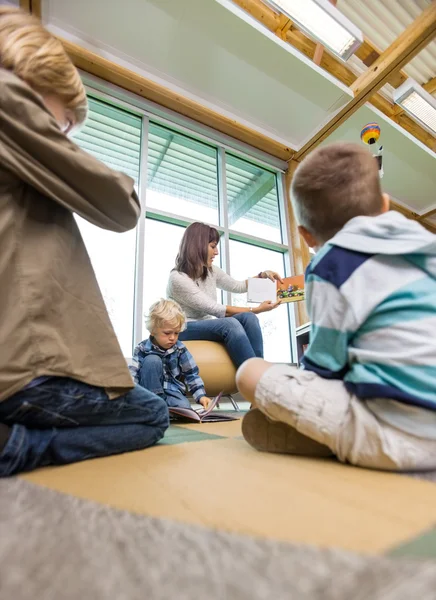 Lehrerin zeigt Kindern Bilderbuch — Stockfoto