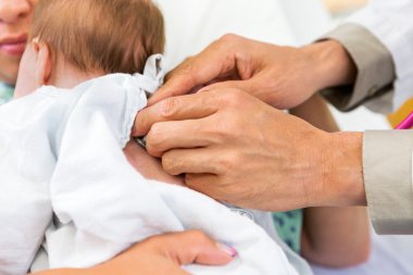 Doktor muayene yeni doğan babygirl stetoskop ile eller.