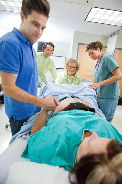 Fürsorglicher Mann hält Frau während der Geburt im Krankenhaus die Hand — Stockfoto