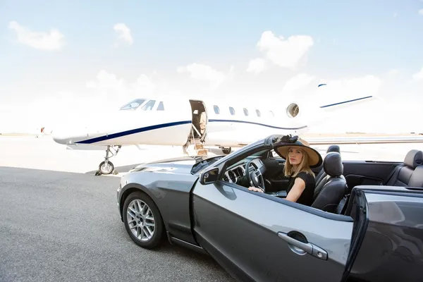 Vrouw ontschepen auto met prive-jet op achtergrond — Stockfoto