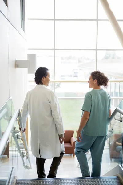 Médico y enfermera conversando mientras camina por las escaleras en Hospita — Foto de Stock