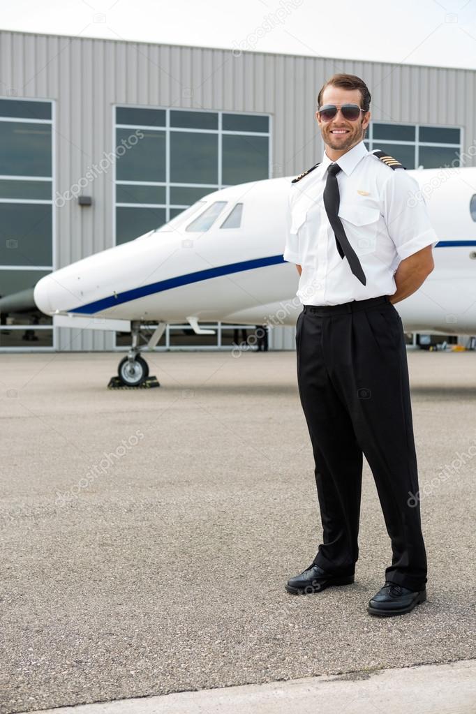 Confident Pilot With Private Jet In Background