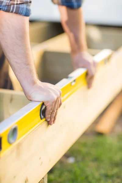 Carpenter 's Hands Checking Level of Wood — стоковое фото