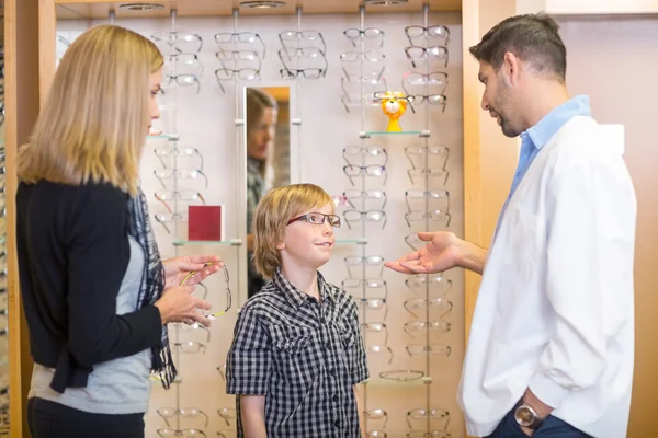 Augenoptiker im Gespräch mit Kunden im Geschäft — Stockfoto