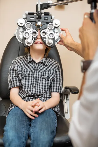 Chico sometiéndose a examen ocular con horopter — Foto de Stock