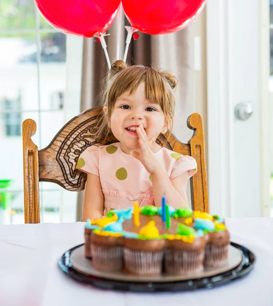 Felice ragazza seduta davanti alla torta di compleanno — Foto Stock