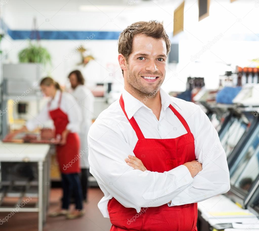 Confident Male Butcher Standing Arms Crossed At Store