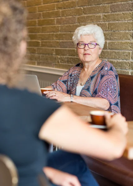 Starszy kobieta z przyjacielem w coffeeshop — Zdjęcie stockowe