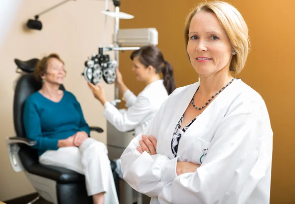Ophtalmologiste confiant avec un collègue examinant le patient — Photo