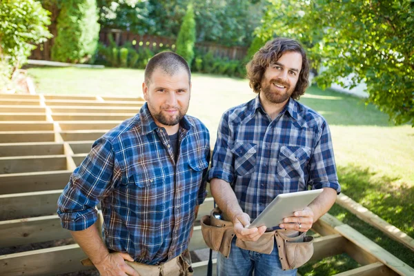 Travailleurs de la construction avec tablette numérique sur le chantier — Photo