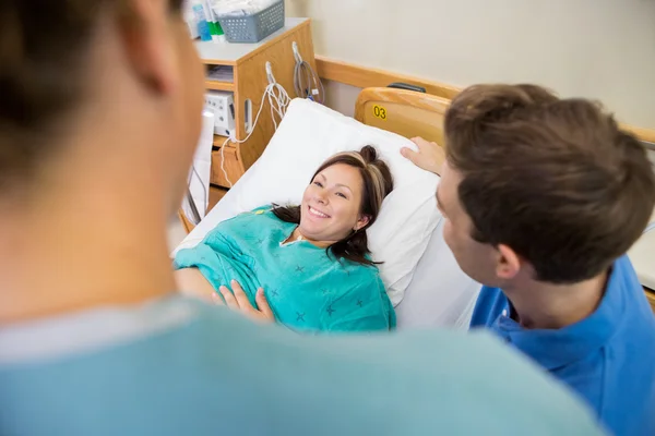 Pregnant Woman Looking At Nurse By Husband In Hospital — Stock Photo, Image