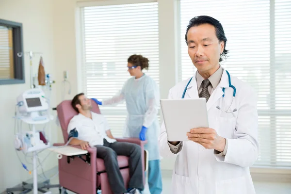 Médecin utilisant la tablette numérique dans la salle de chimio — Photo