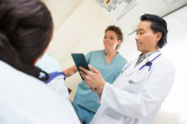 Medisch team met vrouwelijke patiënt in onderzoek kamer — Stockfoto