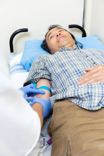 Doctor sacando sangre del brazo del paciente — Foto de Stock