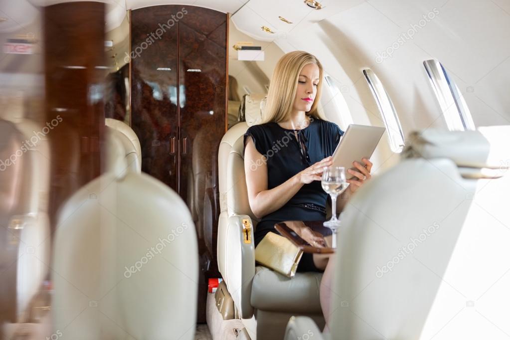 Woman Using Tablet Computer In Private Jet