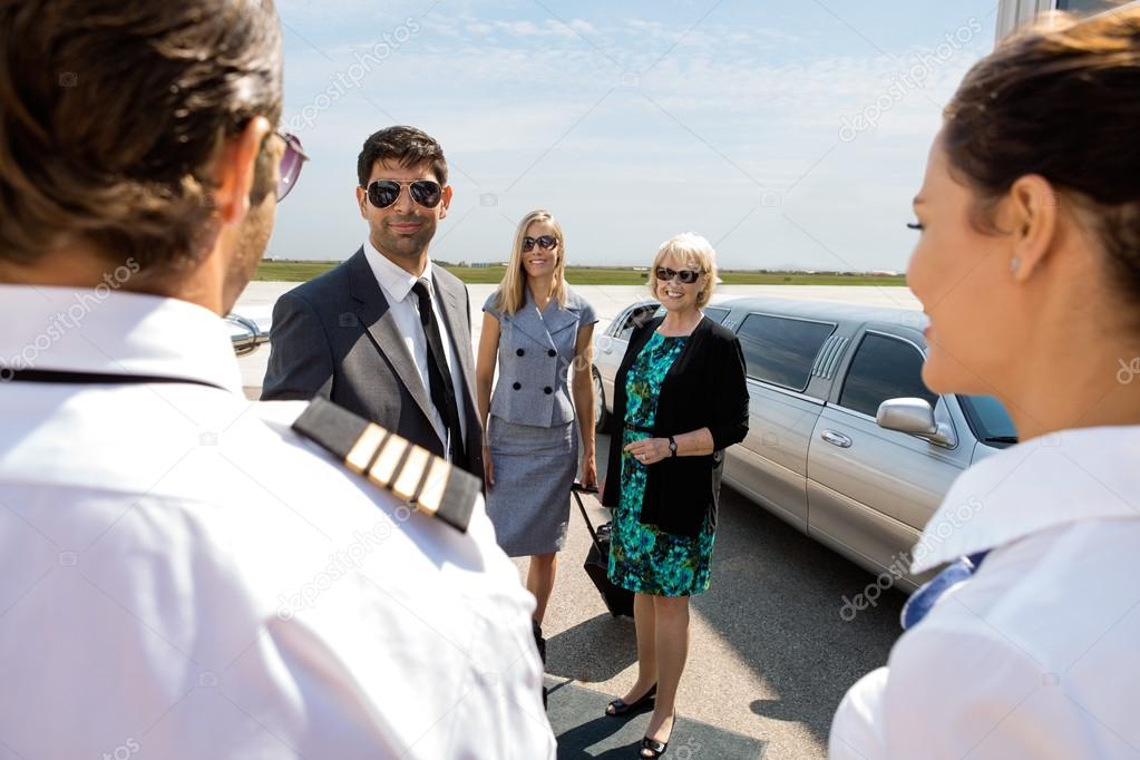 Business Professionals Greeting Pilot And Airhostess At Airport