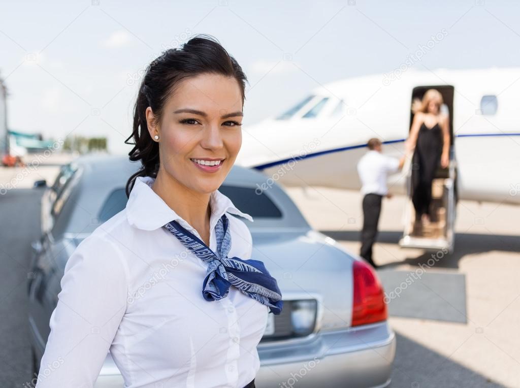 Beautiful Stewardess Standing Against Limousine And Private Jet