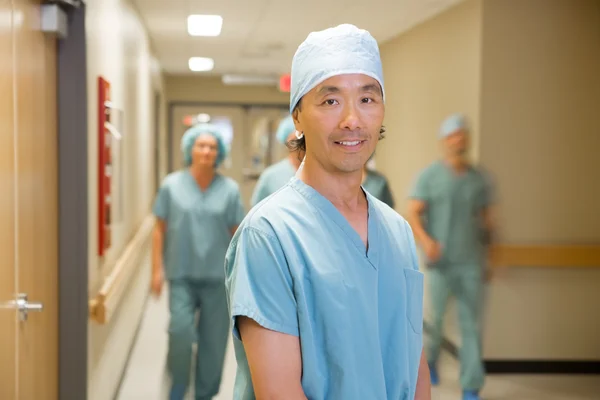 Doktor hastane koridorunda yürürken sağlık ekibi ile — Stok fotoğraf