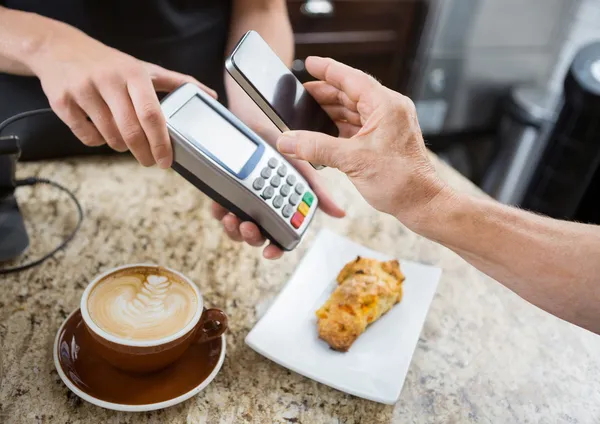 Kunde bezahlt per Handy über elektronisches Lesegerät bei ca. — Stockfoto