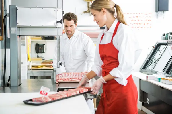 Slaktare bearbetning kött i butiken — Stockfoto