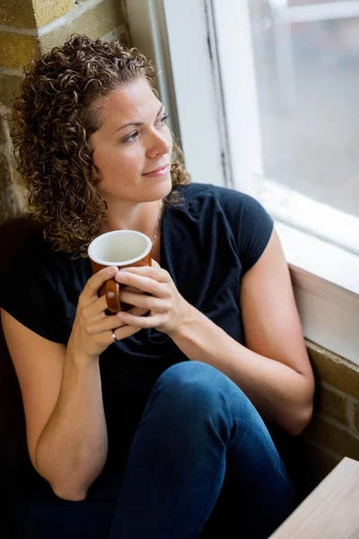 Женщина, смотрящая в окно в Кафе — стоковое фото