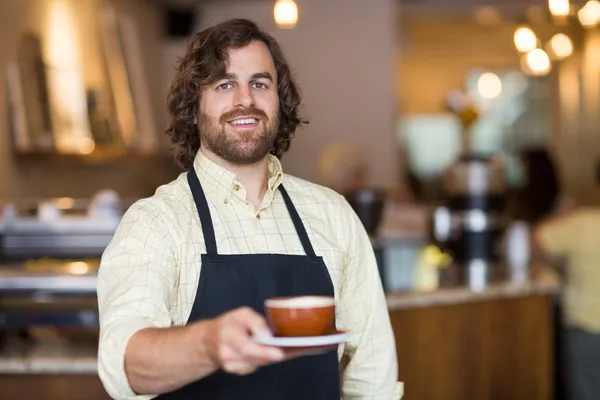 カフェでコーヒー カップを保持するいると確信してのウェイター — ストック写真