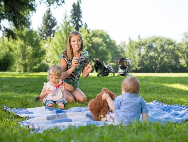 Moeder fotograferen kinderen in park — Stockfoto