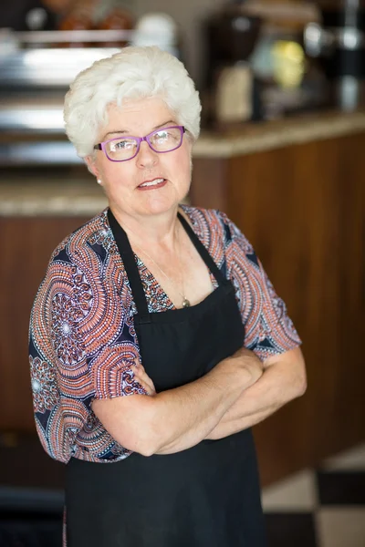 Eigenaar met gekruiste armen permanent in cafetaria — Stockfoto