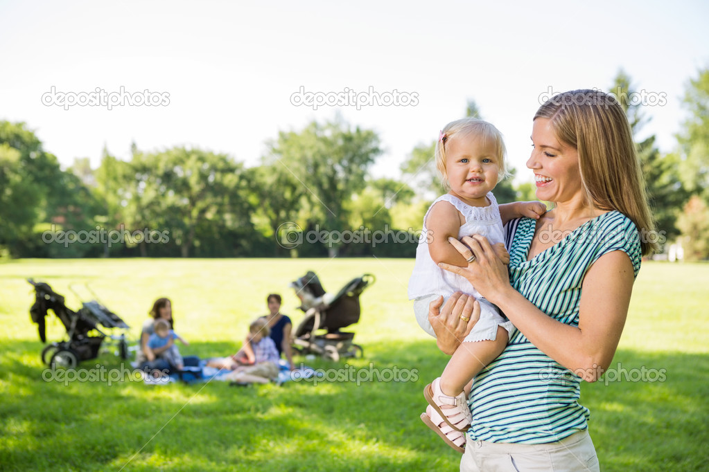 Mother Looking At Cute Daughter In Park