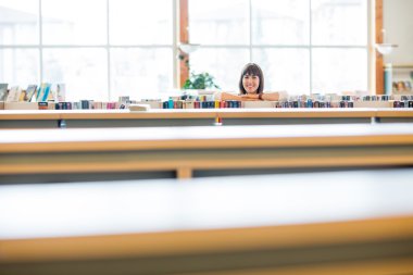 Kitaplığındaki kitap eğilerek öğrenci