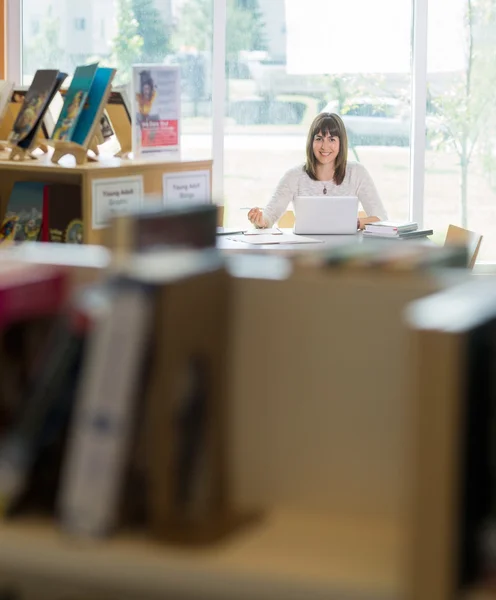 Uczeń z laptop studiów w bibliotece — Zdjęcie stockowe