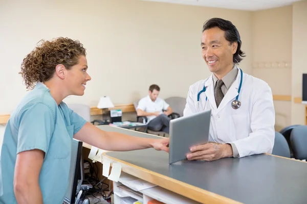 Arts en verpleegkundige met behulp van digitale Tablet PC bij de receptie van het ziekenhuis — Stockfoto