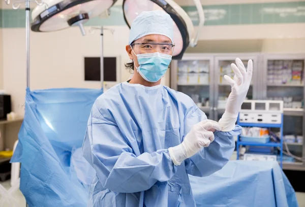 Cirujano con guantes en la sala de operaciones — Foto de Stock