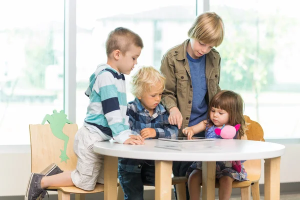 Studenti pomocí tabletového počítače v knihovně — Stock fotografie