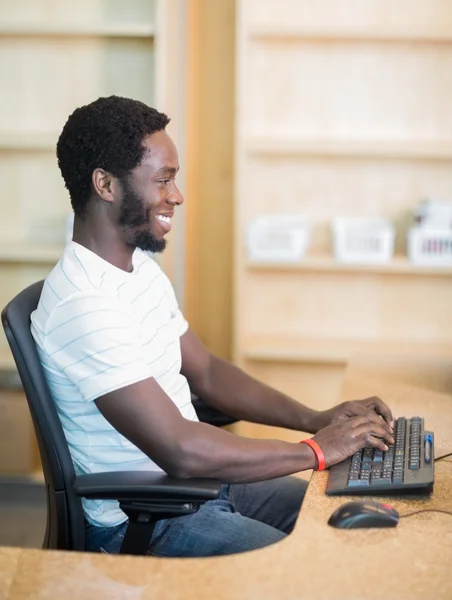 Bibliothecaris werken op de computer aan bibliotheek Bureau — Stockfoto