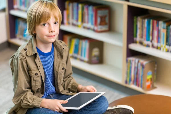 Ragazzo con tavoletta digitale in biblioteca — Foto Stock