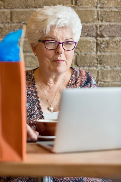 Klant met behulp van laptop in café — Stockfoto