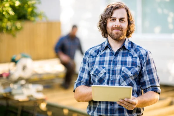 Arbeider houden digitale tablet met collega werken in ba — Stockfoto