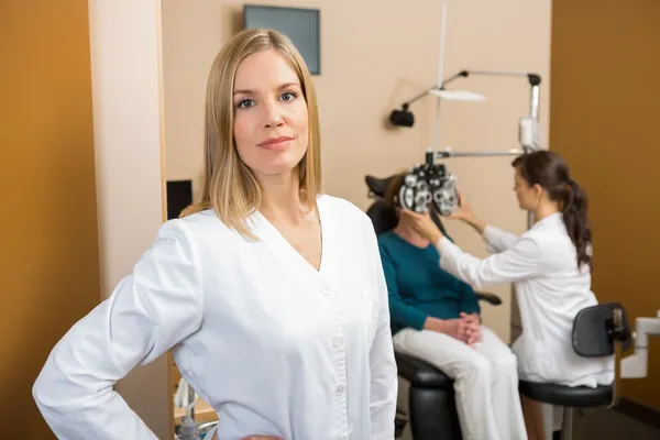 Eyecare specialista s kolegou vyšetřující pacienta — Stock fotografie