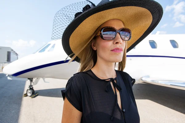 Elegante vrouw permanent tegen prive-jet — Stockfoto