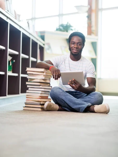 Estudante com tablet digital na biblioteca — Fotografia de Stock