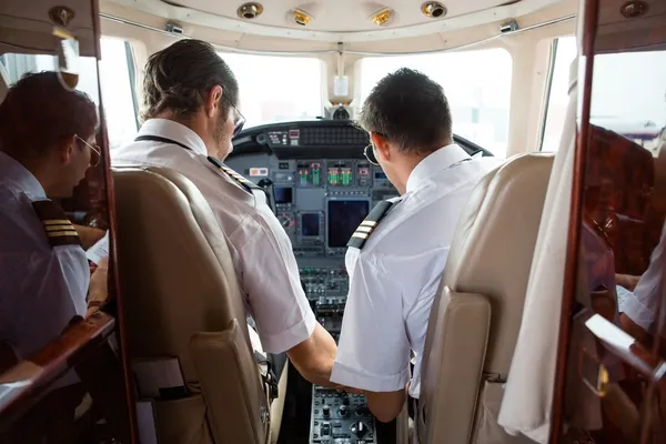 Pilot und Copilot im Cockpit eines Firmenjets — Stockfoto