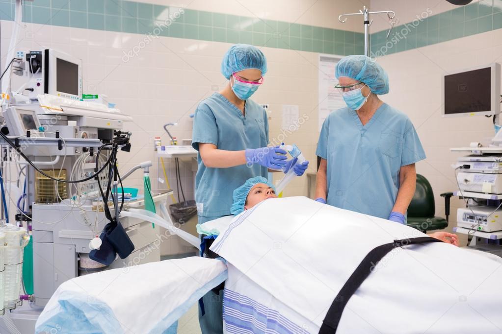 Nurse Adjusting Oxygen Mask On Patient