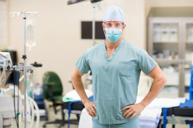 Surgeon With Hands On Hips In Operation Room clipart