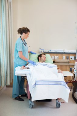 Nurse Standing By Patient Receiving Renal Dialysis clipart