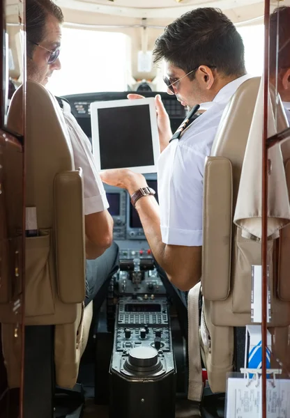Piloot tonen digitale Tablet PC aan copiloot in cockpit — Stockfoto