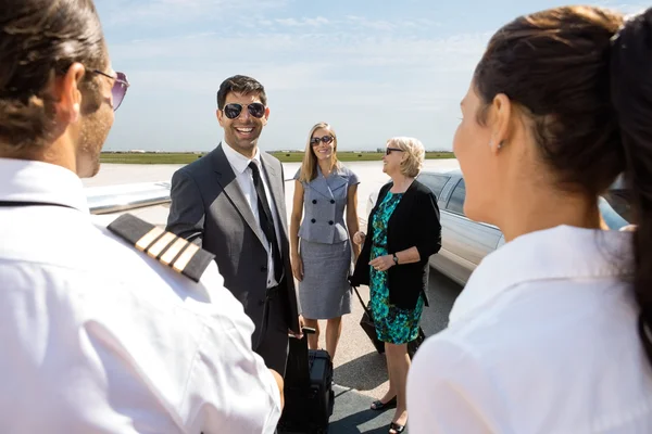 Ludzie biznesu pozdrowienie pilota i airhostess na lotnisko termina — Zdjęcie stockowe