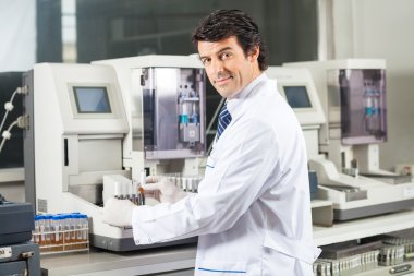 Scientist Using Urine Analyzer To Test Samples clipart